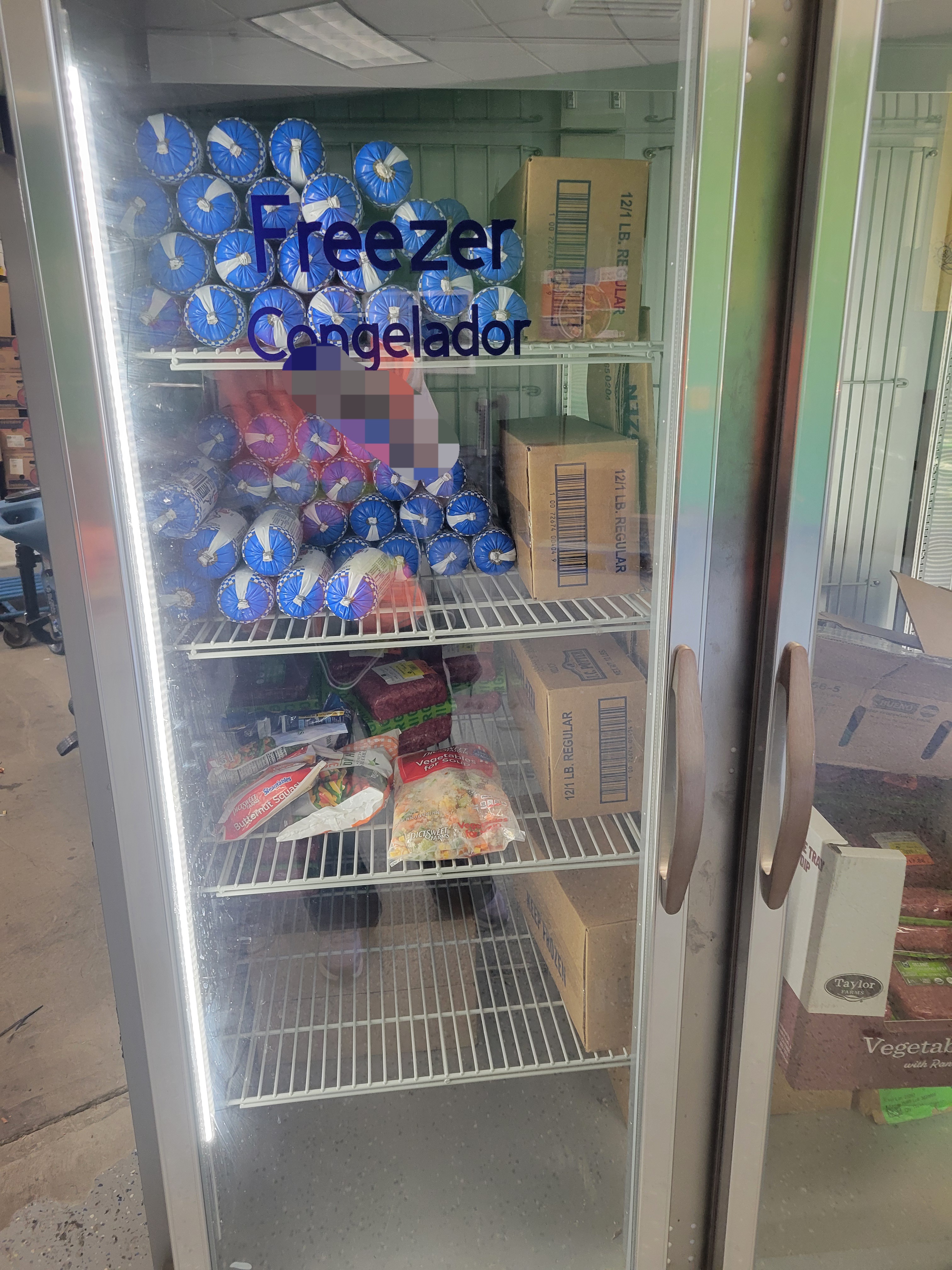 Meats and bags of produce in a freezer.